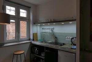 una pequeña cocina con fregadero y ventana en ROOMS BYTOM en Bytom