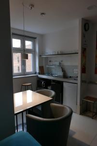 kuchnia ze stołem, krzesłami i blatem w obiekcie ROOMS BYTOM w Bytomiu
