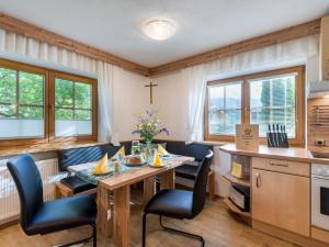 een keuken en eetkamer met een tafel en stoelen bij Landhaus Exenberger / Ferienwohnung Smaragd in Bramberg am Wildkogel