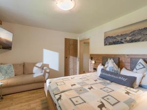 1 dormitorio con 1 cama y 1 sofá en Landhaus Exenberger / Ferienwohnung Smaragd, en Bramberg am Wildkogel