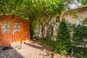 een huis met een houten deur en een boom bij Cottage near Ferrari's City & Pavarotti's House in Montale