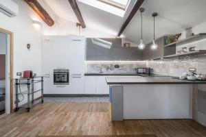 een grote keuken met witte kasten en een houten vloer bij Cottage near Ferrari's City & Pavarotti's House in Montale