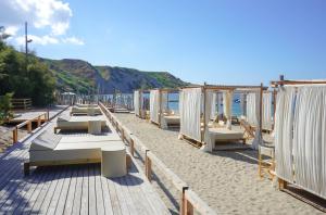 a row of tables and chairs on a beach at Praia Art Resort - Small Luxury Hotels of the world in Le Castella