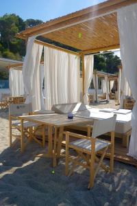 a wooden table and chairs under a pavilion at Praia Art Resort - Small Luxury Hotels of the world in Le Castella +152 photos