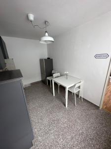 Zimmer mit einem weißen Tisch und einem Kühlschrank. in der Unterkunft Schöne Wohnung im Herzen von Köln Ehrenfeld in Köln