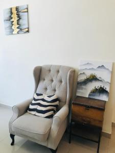 a chair with a pillow on it next to a table at Apartment in Dubai