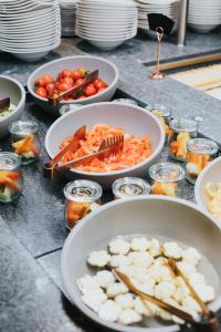 einen Tisch mit Schalen mit Lebensmitteln und Schalen mit Gemüse in der Unterkunft Hotel Tauernhof in Großarl