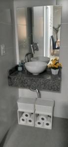 a bathroom counter with a sink and a bowl at Apto NOVO Sensacional Acqua Park com Piscina e Garagem in Pelotas