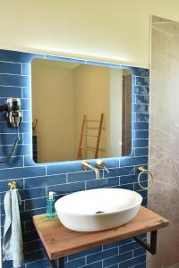 a bathroom with a white sink and a mirror at Kerkhotel Bij De Pastorie in Reitsum