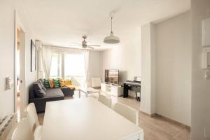 Refurbished 4* apartment with great balcony في لا مانغا ذيل مار مينور: غرفة معيشة بيضاء مع طاولة وأريكة