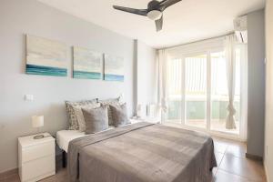 una camera da letto con un letto con un ventilatore a soffitto e una finestra di Refurbished 4* apartment with great balcony a La Manga del Mar Menor
