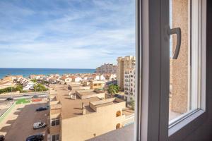 ein Fenster mit Stadt- und Meerblick in der Unterkunft Refurbished 4* apartment with great balcony in La Manga del Mar Menor