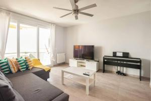 ein Wohnzimmer mit Sofa und Klavier in der Unterkunft Refurbished 4* apartment with great balcony in La Manga del Mar Menor