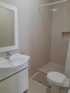 蓬杜歐魯的住宿－Tropicana Guesthouse，白色的浴室设有水槽和卫生间。