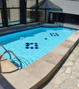 a swimming pool with a tile pattern on it at Apart Hotel 48 in Mogi das Cruzes