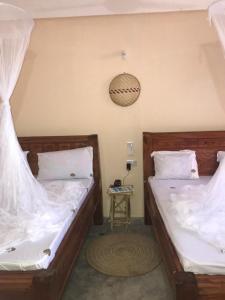 two beds sitting next to each other in a room at Mohammed Bungalows and Restaurant in Matemwe