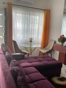 a living room with a purple couch and a table at Newly built house in Accra in Danfa