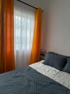 1 dormitorio con cama y cortina de color naranja en Newly built house in Accra, en Danfa