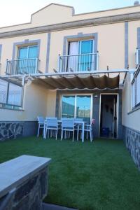 a patio with chairs and a table in front of a house at Brisas de Puerto Rico in Puerto Rico de Gran Canaria