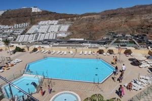 a large swimming pool with people standing around it at Brisas de Puerto Rico in Puerto Rico de Gran Canaria
