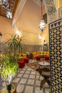 een lobby met banken, tafels en planten bij Riad Diamant De Fes in Fès