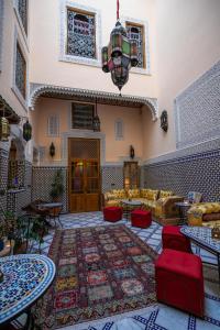 a living room with couches and tables and a rug at Riad Diamant De Fes in Fès