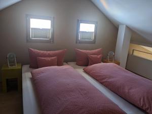 2 camas en una habitación con sábanas rosas y ventanas en Ferienwohnung Kallmünz_Luftschloss, en Kallmünz