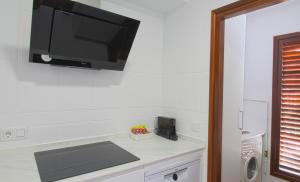 a kitchen with a tv hanging on the wall at El Rincón del Mar in San Vicente de la Barquera