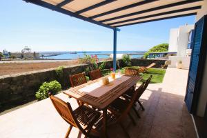 a wooden table and chairs on a patio with a view of the ocean at Casa Bahia de Naos con vistas al mar in Arrecife