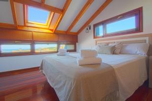 a bedroom with a large bed with two windows at El Rincón del Mar in San Vicente de la Barquera +10 photos