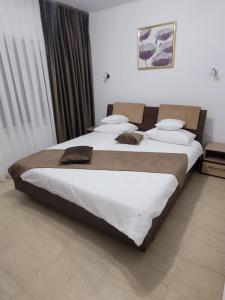 1 dormitorio con 2 camas con sábanas blancas en David INN, en Băile Felix