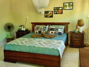 Schlafzimmer mit einem Bett mit einem Holzrahmen und Kissen in der Unterkunft Mekong Delta Ricefield Lodge in Cần Thơ