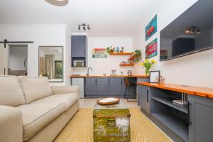 a living room with a couch and a kitchen at The Blue Door Guesthouse in East London