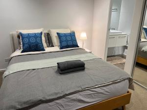 a bedroom with a large bed with blue pillows and a mirror at Quiet CBD 3b2b apartment + free parking in Melbourne +8 photos