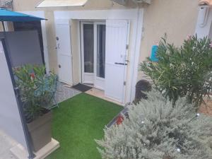 un jardín con césped y plantas frente a una puerta en Bienvenue chez nous, en Saint-Martin-de-Brômes