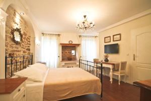 Schlafzimmer mit einem Bett, einem Schreibtisch und einem Kronleuchter in der Unterkunft Casa Bachieri in Rovinj
