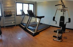 a gym with a treadmill and two exercise bikes at Apart Hotel 48 in Mogi das Cruzes