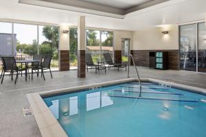 a swimming pool in a house with a table and chairs at Fairfield by Marriott Inn & Suites Yankton in Yankton