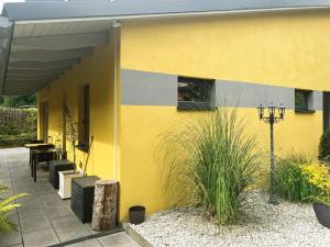 ein gelbes Haus mit einem Tisch und einem Fenster in der Unterkunft Ferienhaus Nicole II, Barrierefrei, mit HIRO Lift in Quedlinburg