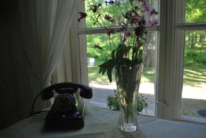 a vase of flowers sitting on a table next to a window at Kirjakkalan Ruukkikylä in Teijo