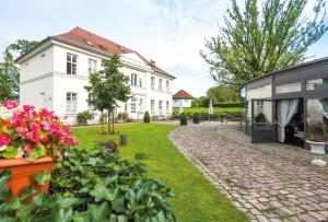 une maison avec un jardin et quelques fleurs dans une cour dans l'établissement Hotel Prinzenpalais Bad Doberan, à Bad Doberan