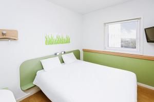 1 dormitorio con cama y ventana en ibis Budget Luxembourg Sud en Livange