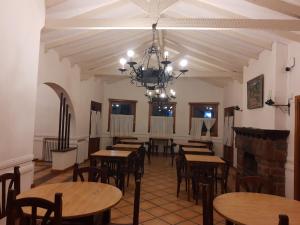 un comedor con mesas y sillas y una lámpara de araña en La Castellana Hotel de Sierras en Valle Hermoso