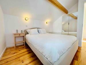 a bedroom with a large white bed and a wooden floor at New Amazing Cozy House in the heart Lisbon in Lisbon
