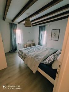 um quarto com uma cama com cortinas azuis em Plane Tree House em Próti