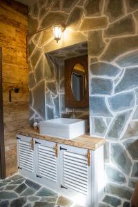 a bathroom with a sink and a stone wall at Ξενωνας Ασημακοπουλου in Diakopto