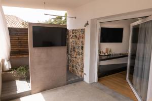 um quarto com uma porta de vidro deslizante e uma televisão em Praia Art Resort - Small Luxury Hotels of the world em Le Castella