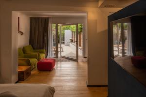 1 dormitorio con sala de estar con sofá y silla en Praia Art Resort - Small Luxury Hotels of the world, en Le Castella