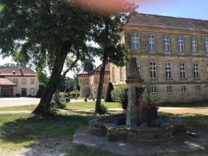 an old stone building with a potted plant in front of it at Wohnen im idyllischen Schlosshof in Franken in Ebern