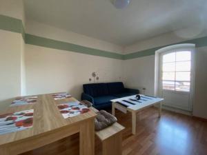 a living room with a blue couch and a table at Wanderurlaub mit Hund in Harra